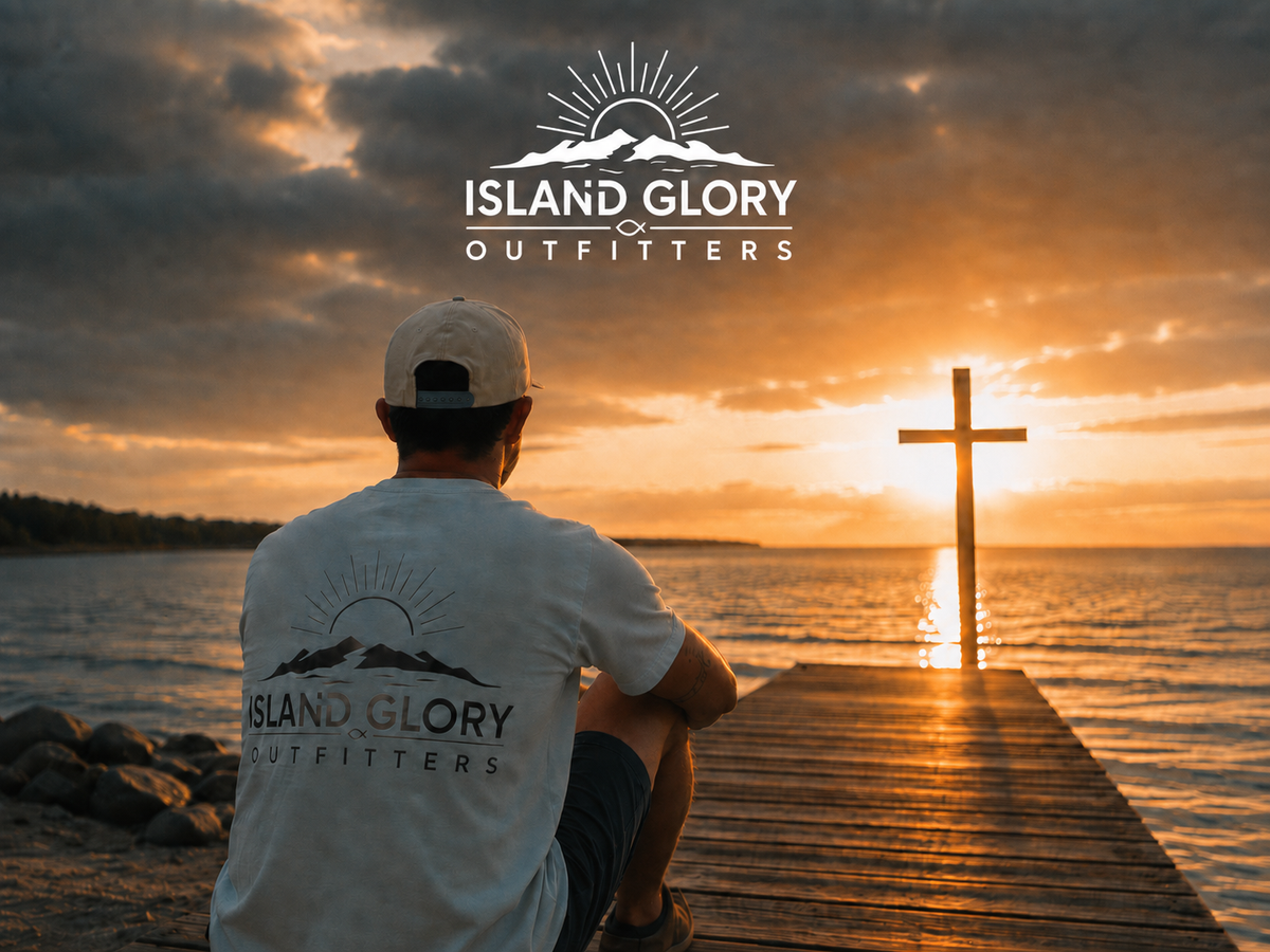 A man on a dock facing sunrise over the water, with Island Glory artwork and a cross ahead in the light.