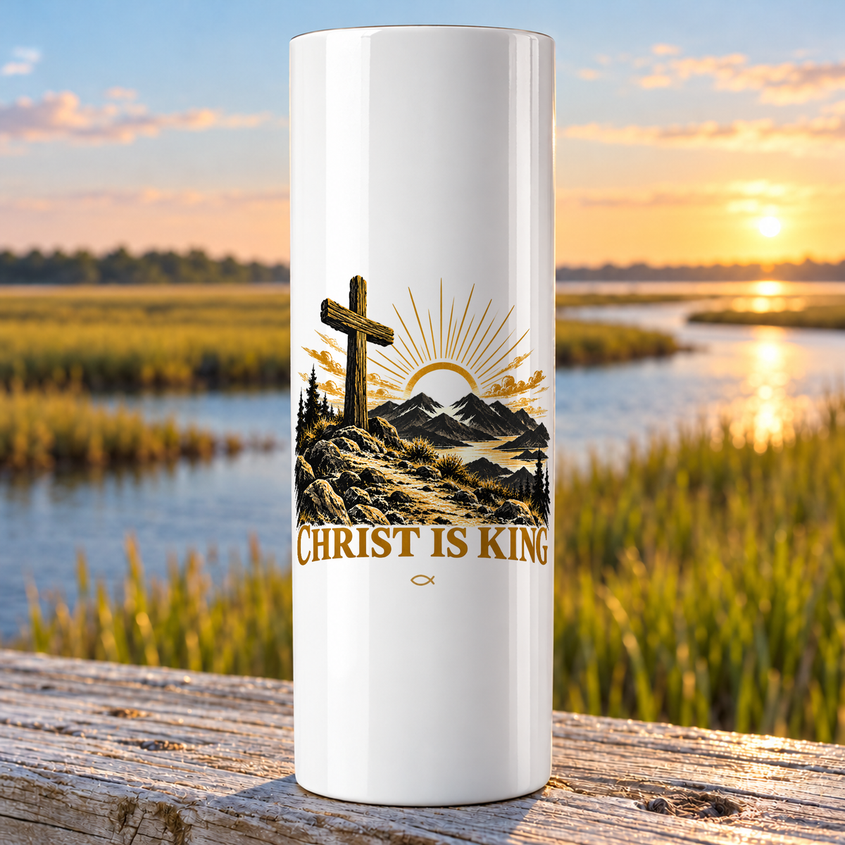 Christ Is King design on a white Hogg 20 oz skinny tumbler beside an Eastern North Carolina coastal marsh.