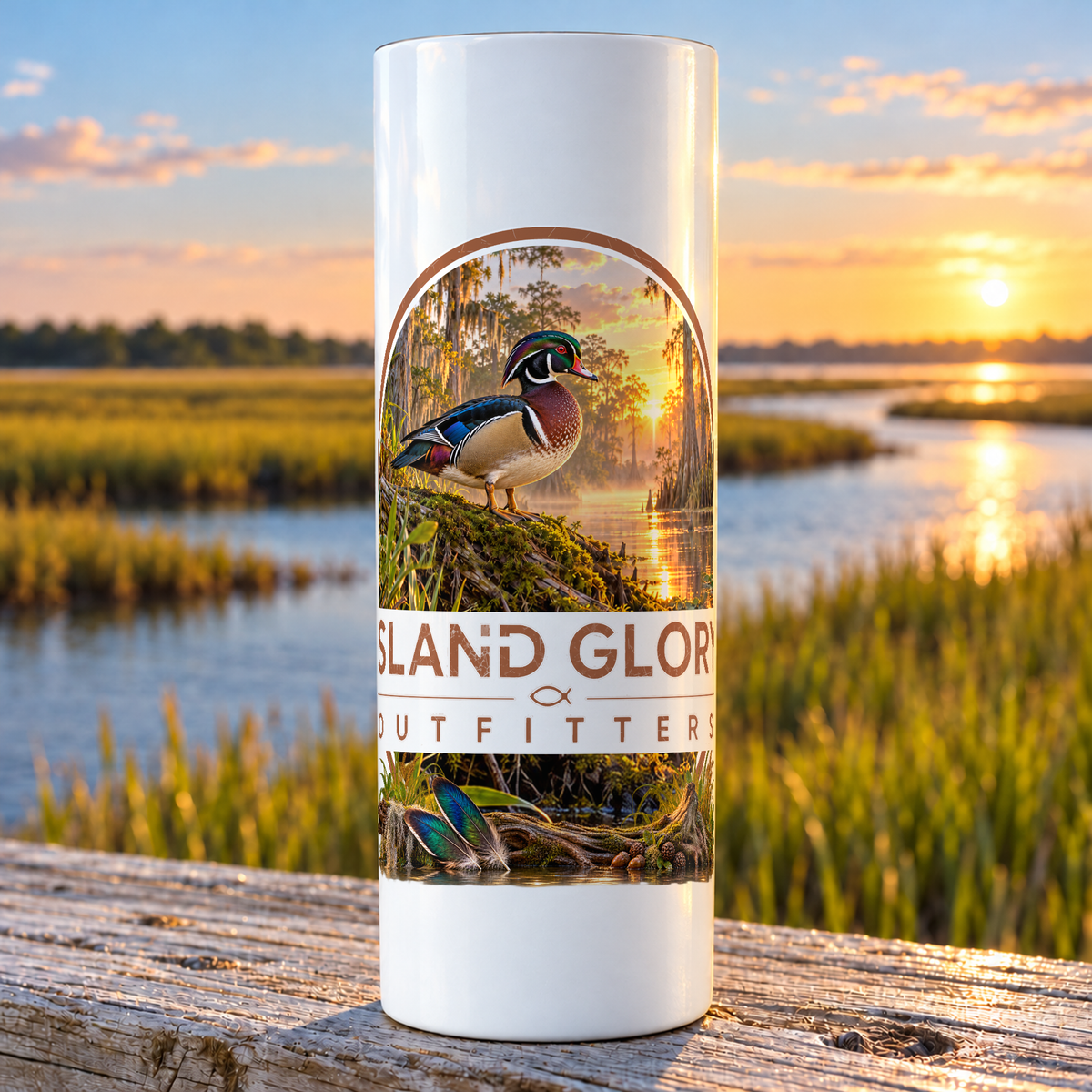 Wood Duck Creek design on a white Hogg 20 oz skinny tumbler beside an Eastern North Carolina coastal marsh.